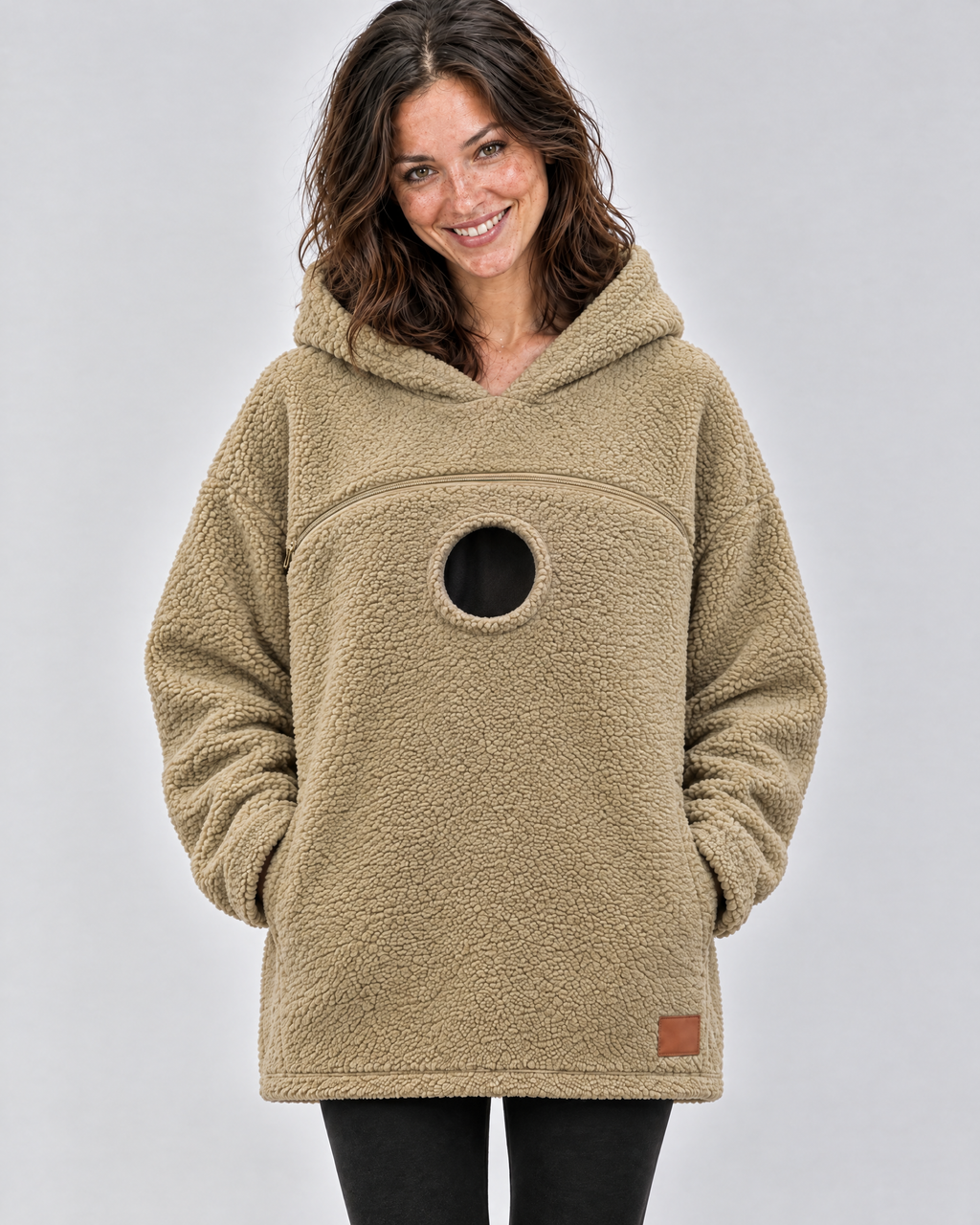 Khaki pouch hoodie worn empty, showing the chest zipper and the round opening below it