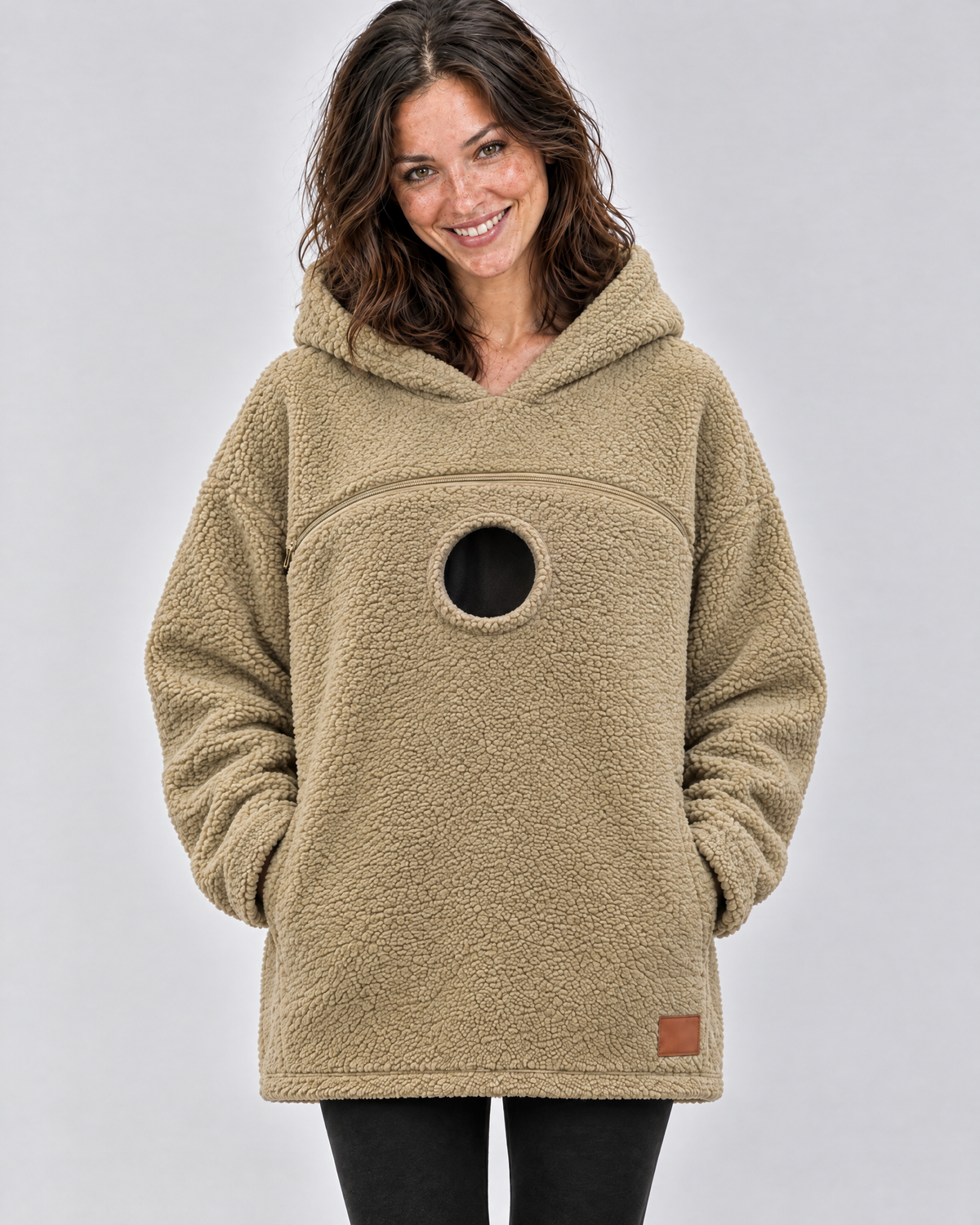 Khaki pouch hoodie worn empty, showing the chest zipper and the round opening below it