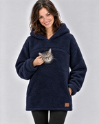 Woman in a navy pouch hoodie cupping the cheek of the silver tabby cat peeking out of the chest opening