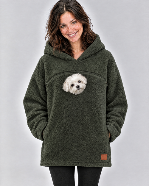 Woman laughing in an army green pouch hoodie with a small white Maltese peeking out below the chest zipper
